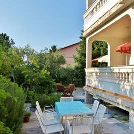 Anamari Apartments, table and chairs in the shade, Mediterranean plants